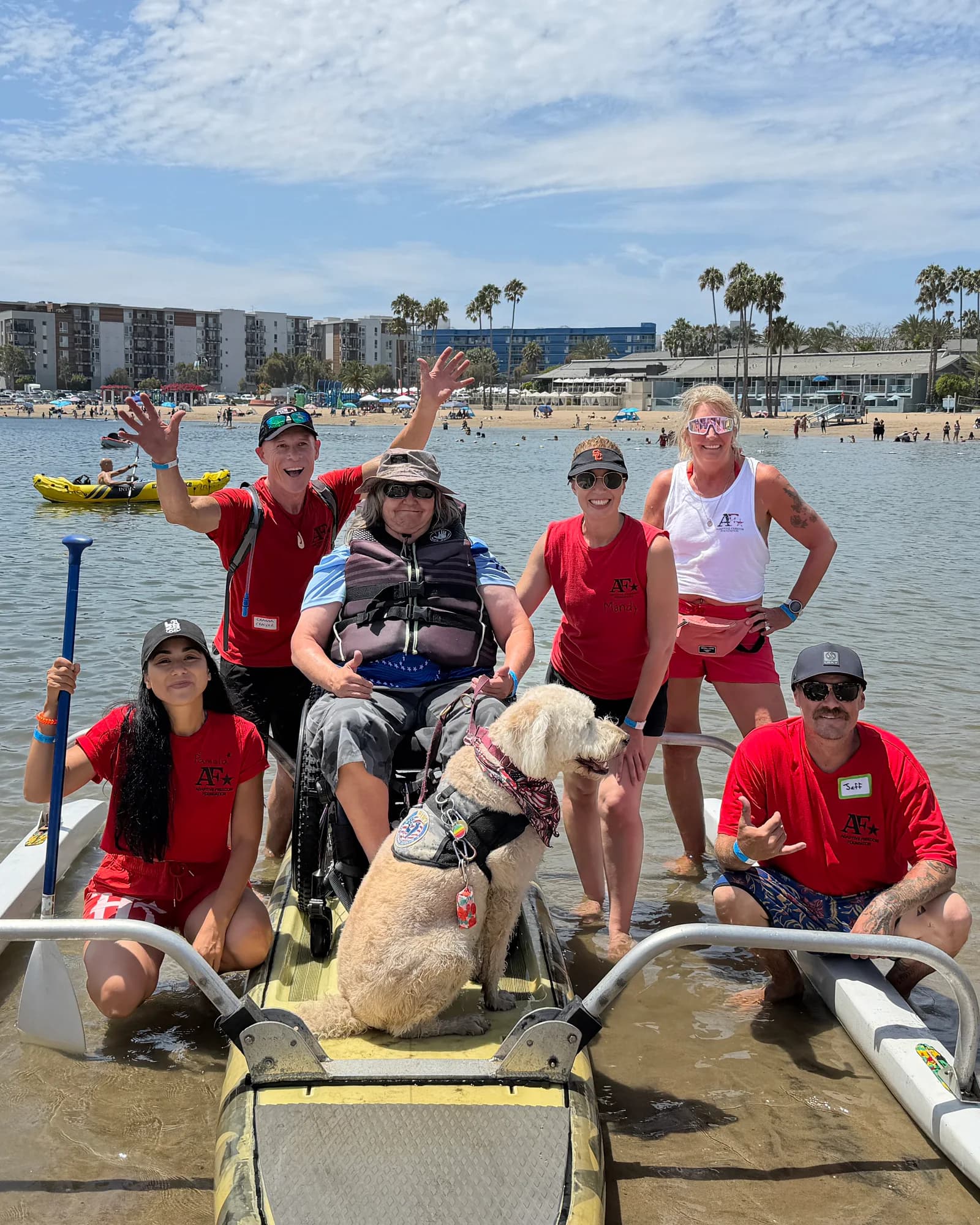 An AFF participant, volunteers, and a service dog together at the shoreline